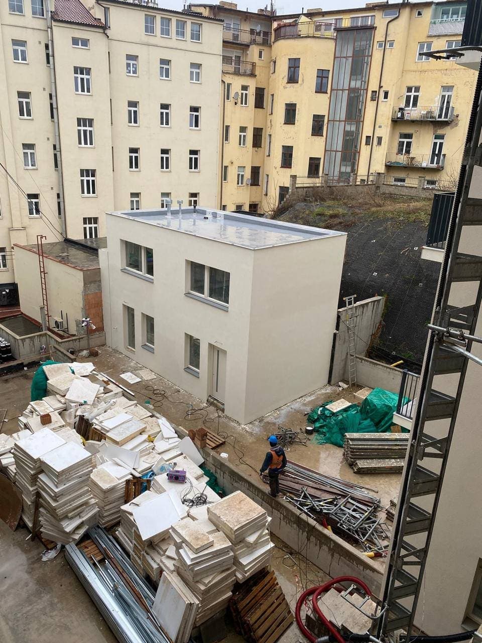 Courtyard extension with the facade finished while construction continues around it