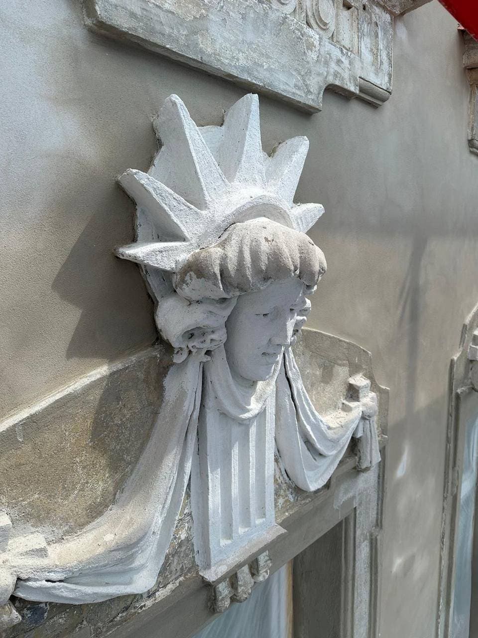 Restored stucco mascaron above a window