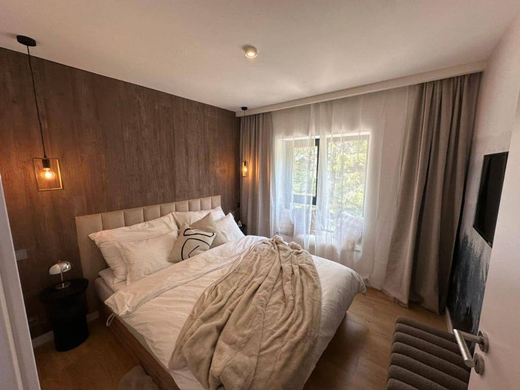 Bedroom with a decorative wood-clad feature wall, Prague