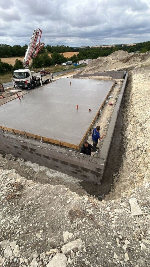 Pouring the foundation slab of a family house with a concrete pump
