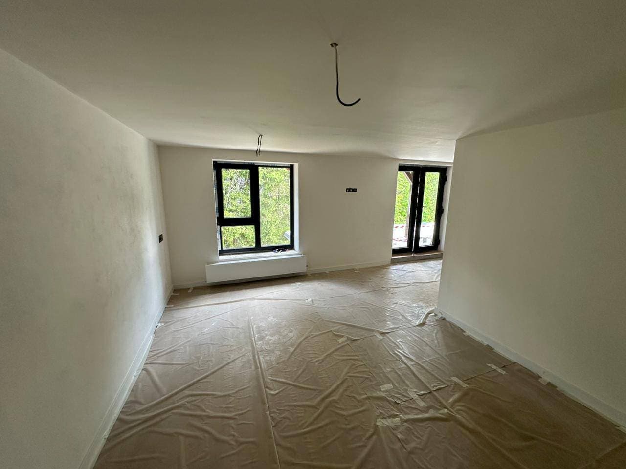 Living room after new plaster and paintwork, the floor still covered